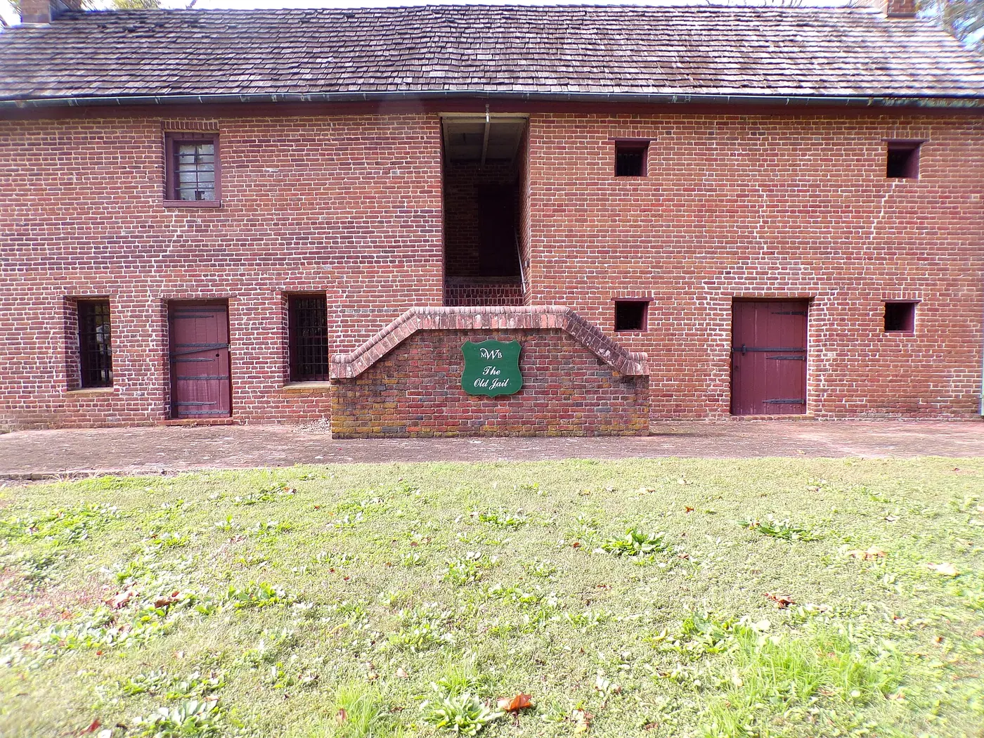 The brick Old Jail in Lancaster, SC, with barred windows and a sign reading The Old Jail